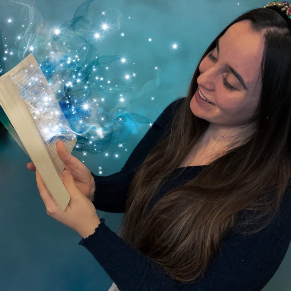 woman opening a book with sparkles of magic coming out