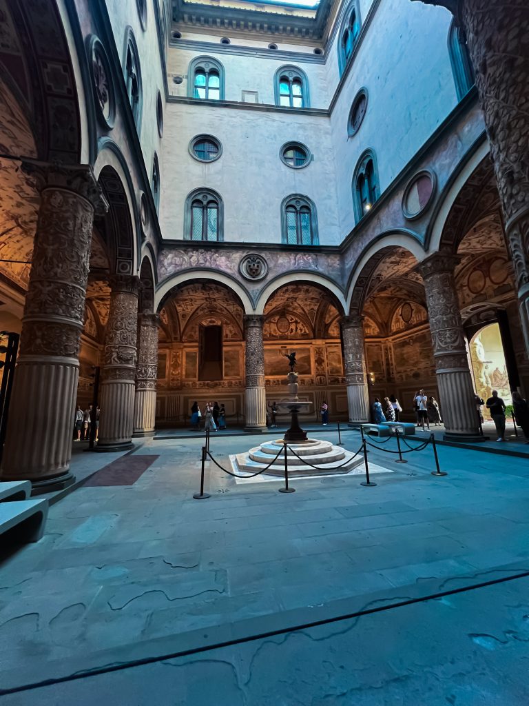 italian piazza with archways and a statue in the centre