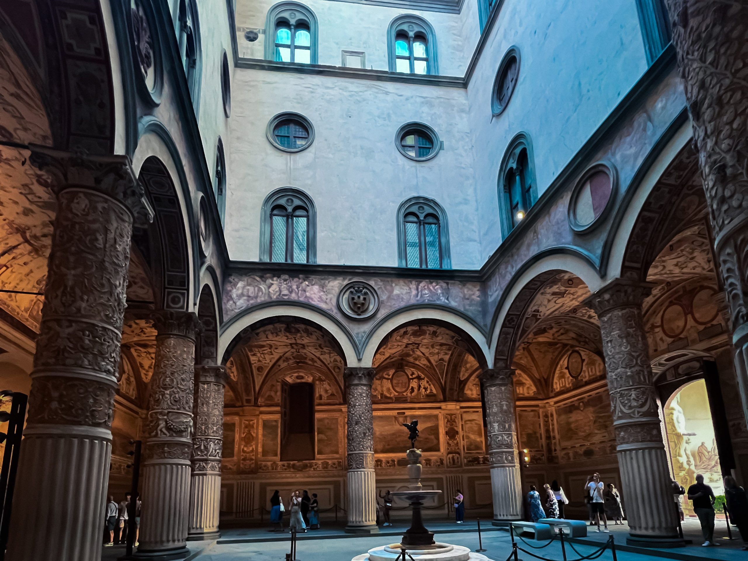 italian piazza with archways and a statue in the centre