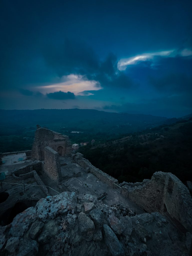 view from a mountain with a broken castle wall