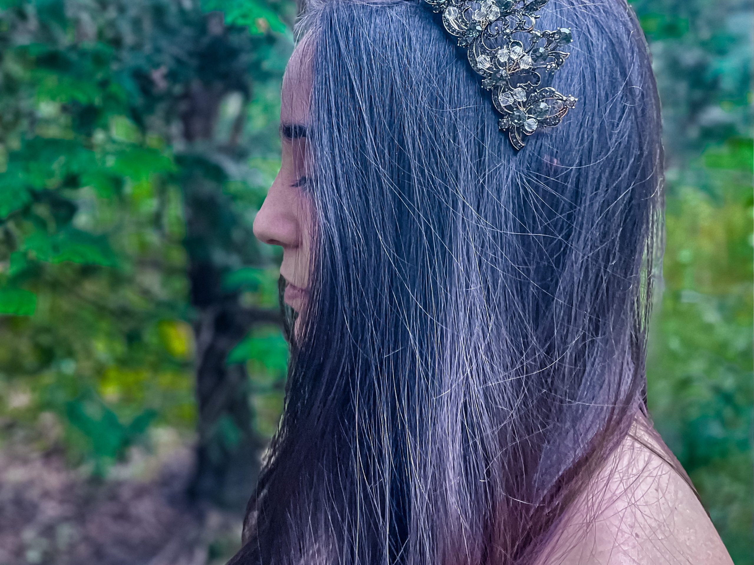 woman standing in a forest wearing a crown